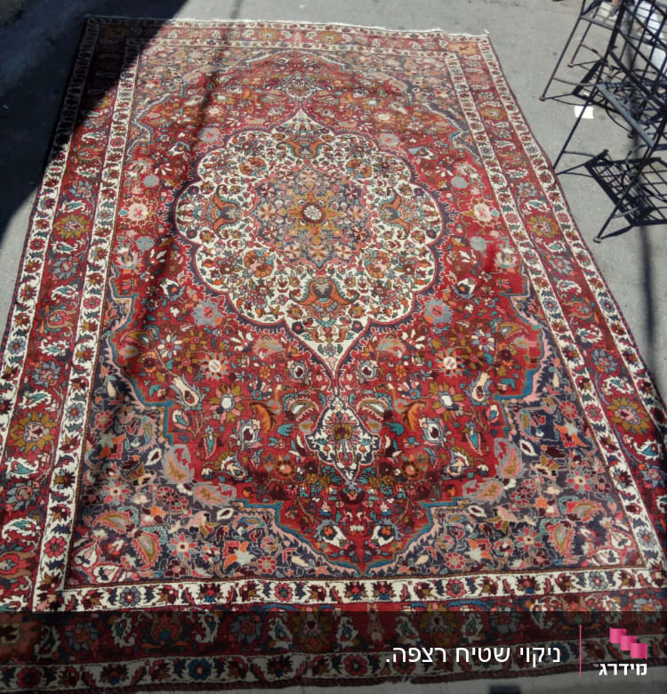 שטיח פרסי צבעוני מונח על רצפה בחוץ